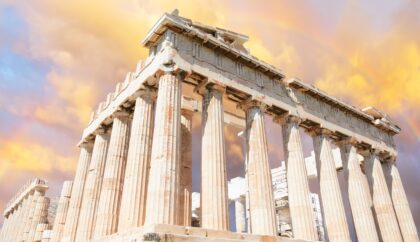 The Parthenon in Athens, Greece, with its ancient columns under a colorful sky featuring a rainbow.