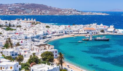 A picturesque view of Mykonos, showcasing its iconic white buildings, vibrant blue sea, and charming waterfront.