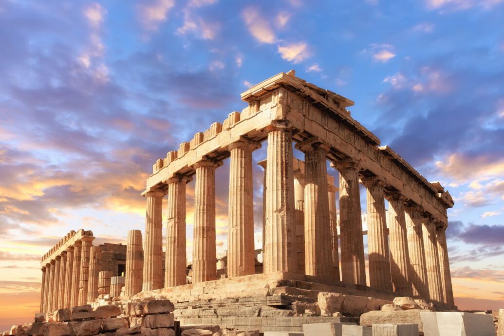 The Parthenon on the Acropolis of Athens, illuminated by soft sunlight, with a dramatic sky in the background.
