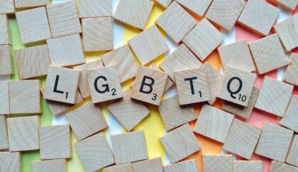 a pack of scrabble letters. In the middle the letters LGBTQ appear in order