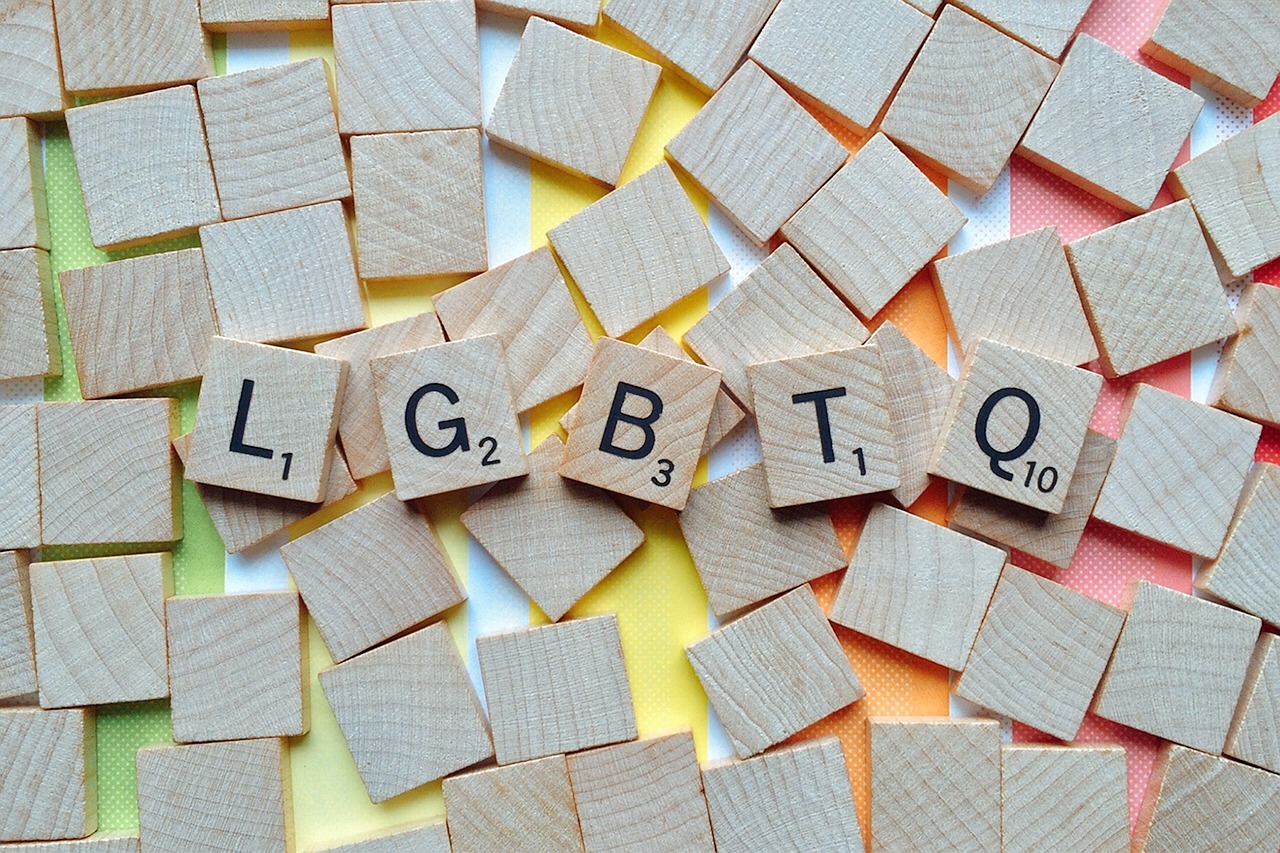 a pack of scrabble letters. In the middle the letters LGBTQ appear in order