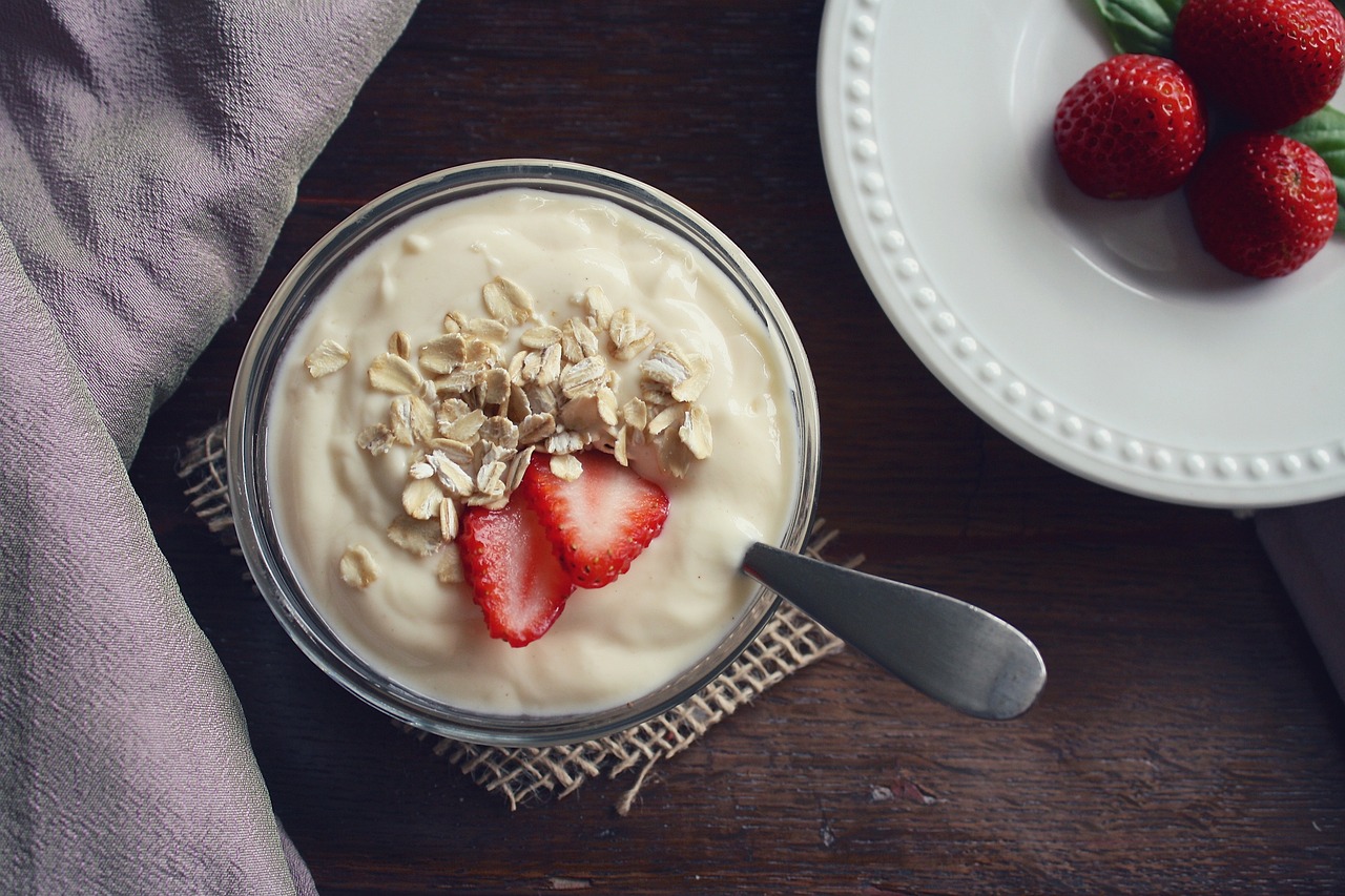 a bowl of greek yogurt with oats and strawberries